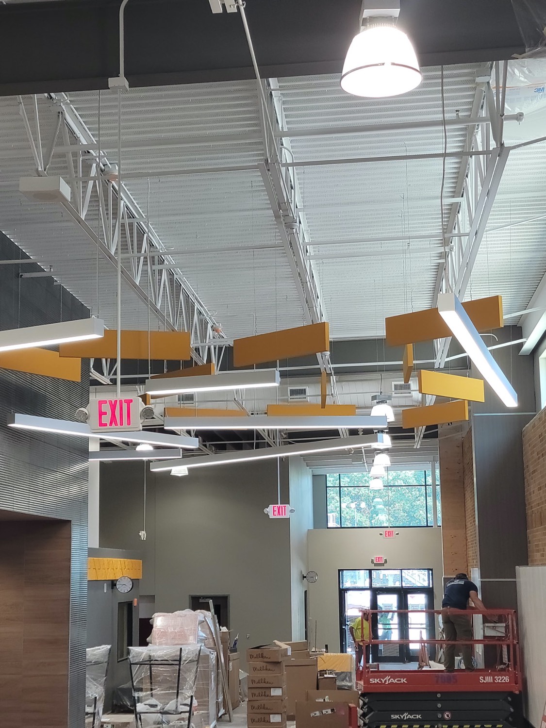 Yellow acoustic baffles and linear lighting in a retail build-out by Skampy Acoustical, Sioux Falls SD